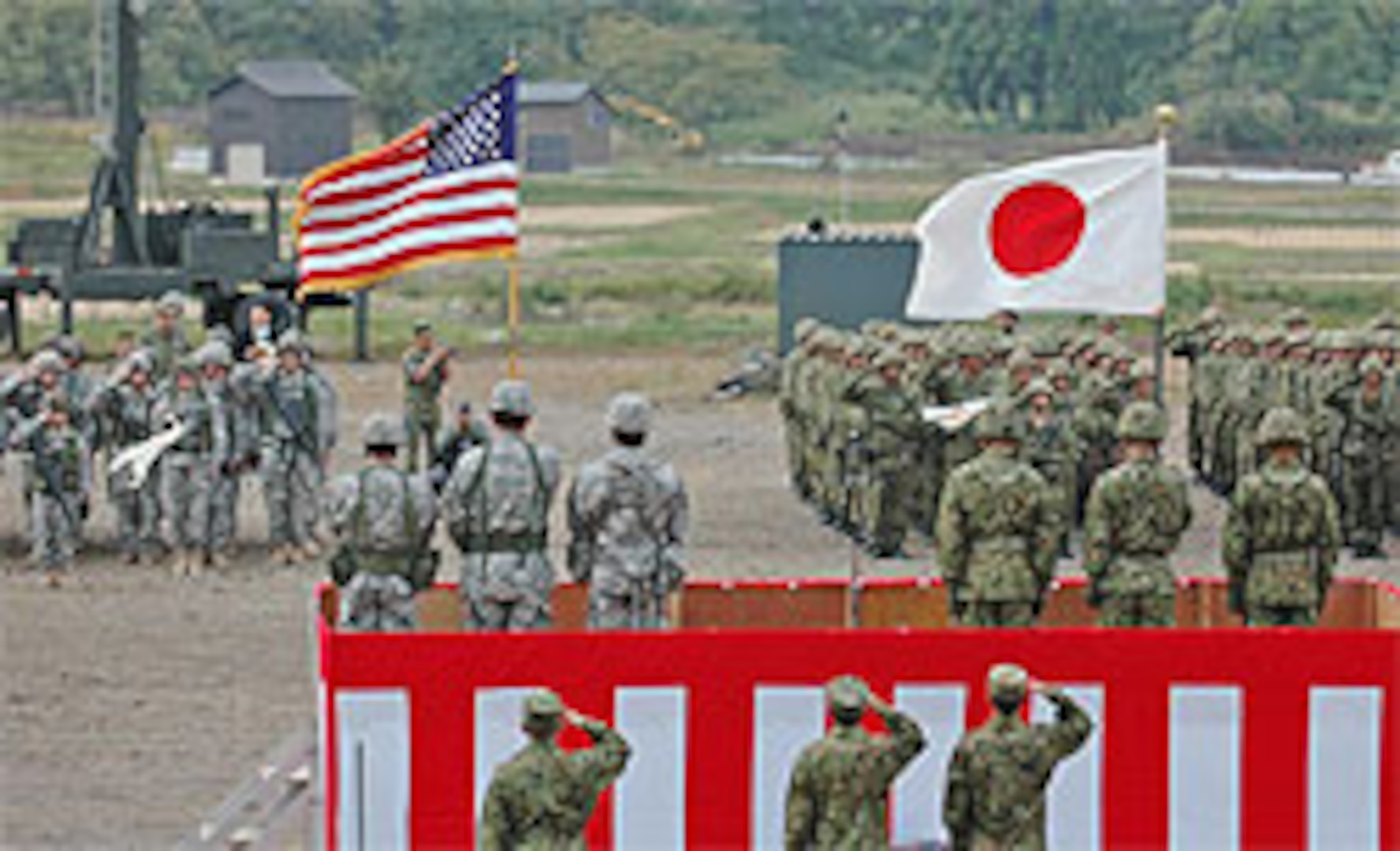 Oregon National Guard and Japan Ground Self Defense Force troops salute the U.S. and Japanese flags during the Orient Shield opening ceremony Monday.