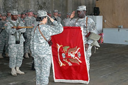 Lt. Col. Patricia Anslow, commander of the Arkansas Army National Guard's 875th Engineer Battalion, and Command Sgt. Maj. Billy Ward proudly uncase the unit colors at a formal transfer of authority ceremony at Camp Striker, Iraq, Nov. 1, 2006. The 875th took over from the Missouri Army National Guard's 110th Engineer Battalion, which is completing a yearlong deployment in support of Operation Iraqi Freedom.