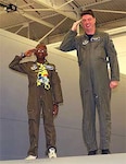 Michael Ogunjimi, 10, of Washington, D.C., joins Air Force Reserve Capt. Scott Clark, 756th Air Refueling Squadron pilot, to salute from the wing of a KC-135 Stratotanker Oct. 27. The 459th Air Refueling Wing and the District of Columbia Air National Guard 113th Wing teamed up to host the "Pilot for a Day" program. "P4D" is a community outreach program that allows military and civilian children of all ages who suffer from serious or chronic medical conditions to visit an installation for a day.