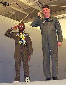 Michael Ogunjimi, 10, of Washington, D.C., joins Air Force Reserve Capt. Scott Clark, 756th Air Refueling Squadron pilot, to salute from the wing of a KC-135 Stratotanker Oct. 27. The 459th Air Refueling Wing and the District of Columbia Air National Guard 113th Wing teamed up to host the "Pilot for a Day" program. "P4D" is a community outreach program that allows military and civilian children of all ages who suffer from serious or chronic medical conditions to visit an installation for a day.