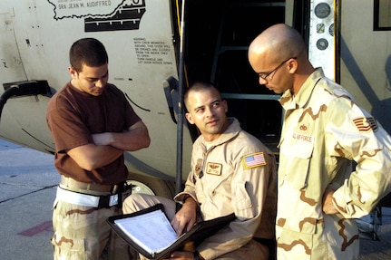 Brothers Senior Airman Jean Audiffred, Master Sgt. Jorge Cantres and Tech. Sgt. Armando Cantres discuss a post-flight check after the aircrew landed and completed a misison. The three are brothers deployed from Muniz Air National Guard, Puerto Rico. They are one line of many families serving in the Puerto Rico Guard. Jean is a C-130 crew chief, Jorge is a C-130 flight engineer, and Armando is a C-130 engine mechanic. (U.S. Air Force photo/) 