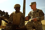 LTG H Steven Blum (right) chief of the National Guard Bureau, talks with Maryland Army National Guard Pfc. Brandon Ross atop a Humvee while visiting Guard members deployed with Joint Task Force-Guantanamo at U.S. Naval Station Guantanamo Bay in mid-November. JTF-GTMO conducts safe and humane care and custody of detained enemy combatants.