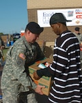 Staff Sgt. Kenneth Rushing accepts a full box of donated food from a volunteer during the Food for Families food drive in Waco Nov. 17.