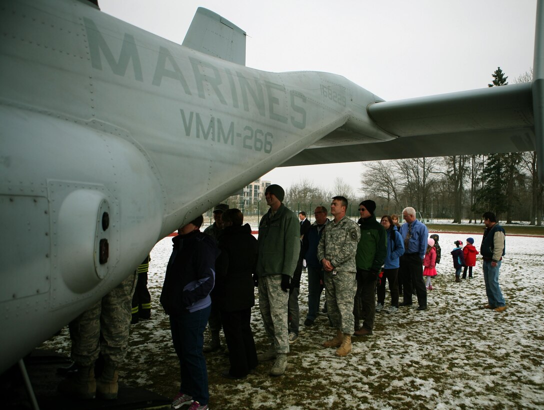 Members from the U.S. Army Garrison Stuttgart, Germany, community wait in line to tour the inside of an MV-22B Osprey from Marine Tiltrotor Squadron 266 (Reinforced), 26th Marine Expeditionary Unit, II Marine Expeditionary Force, Camp Lejeune, N.C., during a capabilities demonstration at Kelly Barracks, March 28. U.S. Marine Corps Forces Europe, U.S. Marine Corps Forces Africa, in coordination with U.S. European Command, U.S. Africa Command, the community of U.S. Army Garrison Stuttgart, Germany, received  “hands-on” experience with the MV-22B Osprey during a capabilities exercise on Patch Barracks, Kelley Barracks, and Stuttgart Army Airfield, that helped to familiarize the combatant commands with the possibilities and new abilities the aircraft could provide throughout their respective area of reach. The three MV-22 Osprey crews flew 1400 nautical miles from the Atlantic Ocean, without having to land to refuel, before arriving two days earlier. The MV-22 Osprey possess twice the speed, can fly twice as high, carry three times the payload, and travels five times the distance of other legacy, medium-lift helicopters. 
