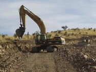 U.S. Marines assigned to Engineer Company, Marine Wing Support Squadron 272, Marine Corps Air Station New River, N.C., use a excavator to clear and shape the side of a mountain to create a ditch to clear water and preserve the road being constructed near the U.S./Mexico border, Mar. 18. The Southwest border infrastructure support mission was coordinated by Joint Task Force North, the Department of Defense unit tasked to provide counterdrug support to the nation’s federal law enforcement agencies. 
