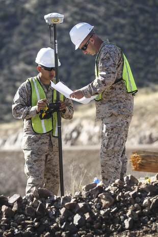 U.S. Marine surveyors and drafters Cpl. Joe Sabun and Lance Cpl. Gill Aluna, assigned to Engineer Company, Marine Wing Support Squadron 272, Marine Corps Air Station New River, N.C., use a GPS-based surveying tool to mark exactly where the Marines need to add or remove material to create a new border road, near Nogales, Ariz., Mar. 19.

