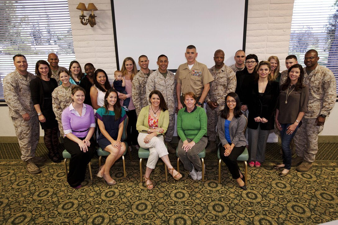 Service members and spouses of Headquarters and Support Battalion and Security and Emergency Services Battalion take a group photo during a Spouse Readiness Seminar, where twenty-one spouses learned about a variety of topics related to military life, here March 28. 