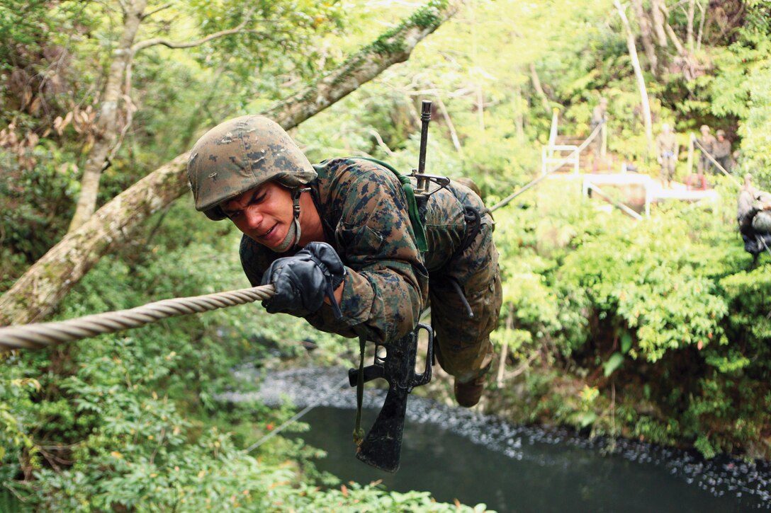 Cpl. Wilkins Vidal crosses the monkey crawl obstacle of the endurance course March 21 at the Jungle Warfare Training Center on Camp Gonsalves during the Headquarters and Service Battalion, Marine Corps Base Camp Smedley D. Butler corporals’ course. Throughout the endurance course, Marines were required to cross numerous natural and man-made obstacles. Vidal is the training noncommissioned officer for Company B, H&S Bn., MCB Camp Butler, Marine Corps Installations Pacific.