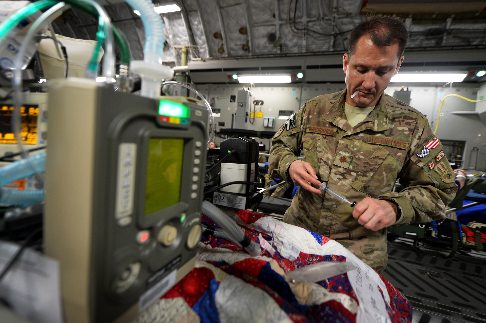 Maj. Michael Mackovich, 455th Expeditionary Aeromedical Evacuation Squadron Critical Care Air Transport Team nurse, prepares to administer intravenous medication during flight out of Bagram Airfield, Afghanistan, March 21, 2013. The CCATT crew is constantly on their feet during the flight to observe and interact with the patients for any signs of medical need. (U.S. Air Force photo/Senior Airman Chris Willis)