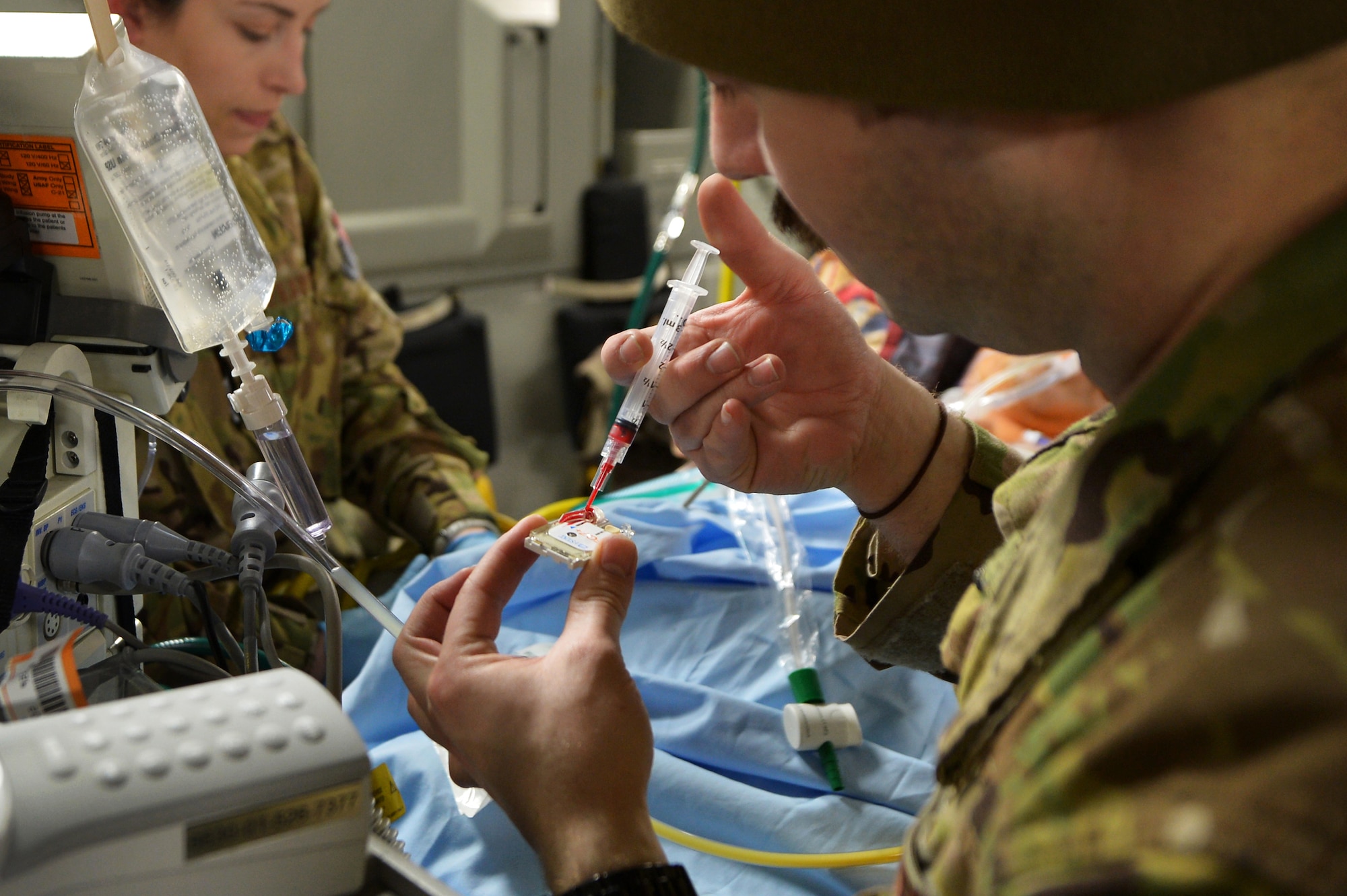 Senior Airman Delton McClary, 455th Expeditionary Aeromedical Evacuation Squadron Critical Care Air Transport Team respiratory therapist, performs an arterial blood gas sampling during flight out of Bagram Airfield, Afghanistan, March 21, 2013.  The results will be used to monitor the patient's hemoglobin and electrolyte levels and guide further resuscitation during the flight.  (U.S. Air Force photo/Senior Airman Chris Willis)
