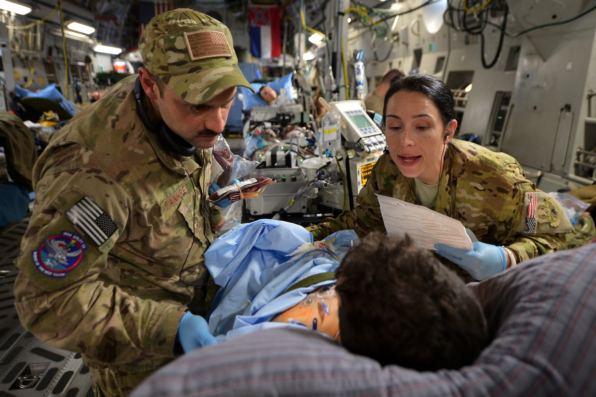 Capt. Mario Ramirez and Capt. Suzanne Morris, members of the 455th Expeditionary Aeromedical Evacuation Squadron Critical Care Air Transport Team, confirm a patient's identity and prepare to administer a blood transfusion during a flight out of Bagram Airfield, Afghanistan, March 21, 2013. A CCATT crew consists of a physician, intensive care nurse and a respiratory therapist, making it possible to move severely injured or gravely ill servicemembers by air.  (U.S. Air Force photo/Senior Airman Chris Willis)