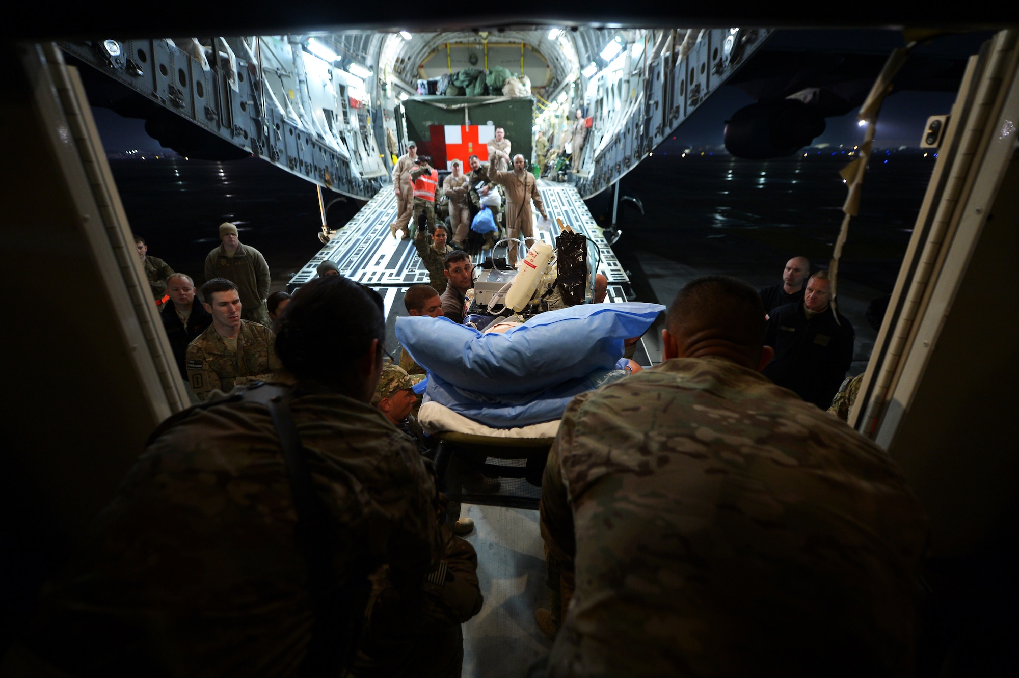 Members of the Contingency Aeromedical Staging Facility and 455th Expeditionary Aeromedical Evacuation Squadron Critical Care Air Transport Team assist patients onto C-17 Globemaster III at Bagram Airfield, Afghanistan, March 21, 2013. The CASF is the relay between the Craig Joint Theater Hospital and aeromedical evacuation missions throughout Afghanistan. (U.S. Air Force photo/Senior Airman Chris Willis)