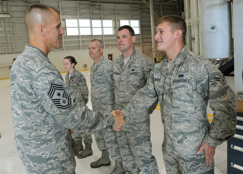 Chief Master Sgt. Steve McDonald, Pacific Air Forces command chief, shakes hands with Airman 1st Class Trevor Gibbins, 15th Maintenance Squadron crew chief, during a tour with 15th Maintenance Group Airmen at Hangar 21, Joint Base Pearl Harbor-Hickam, Hawaii, March 27, 2013. During the tour McDonald thanked each of the units and spoke of the importance of their missions. (U.S. Air Force photo/Tech. Sgt. Jerome S. Tayborn)