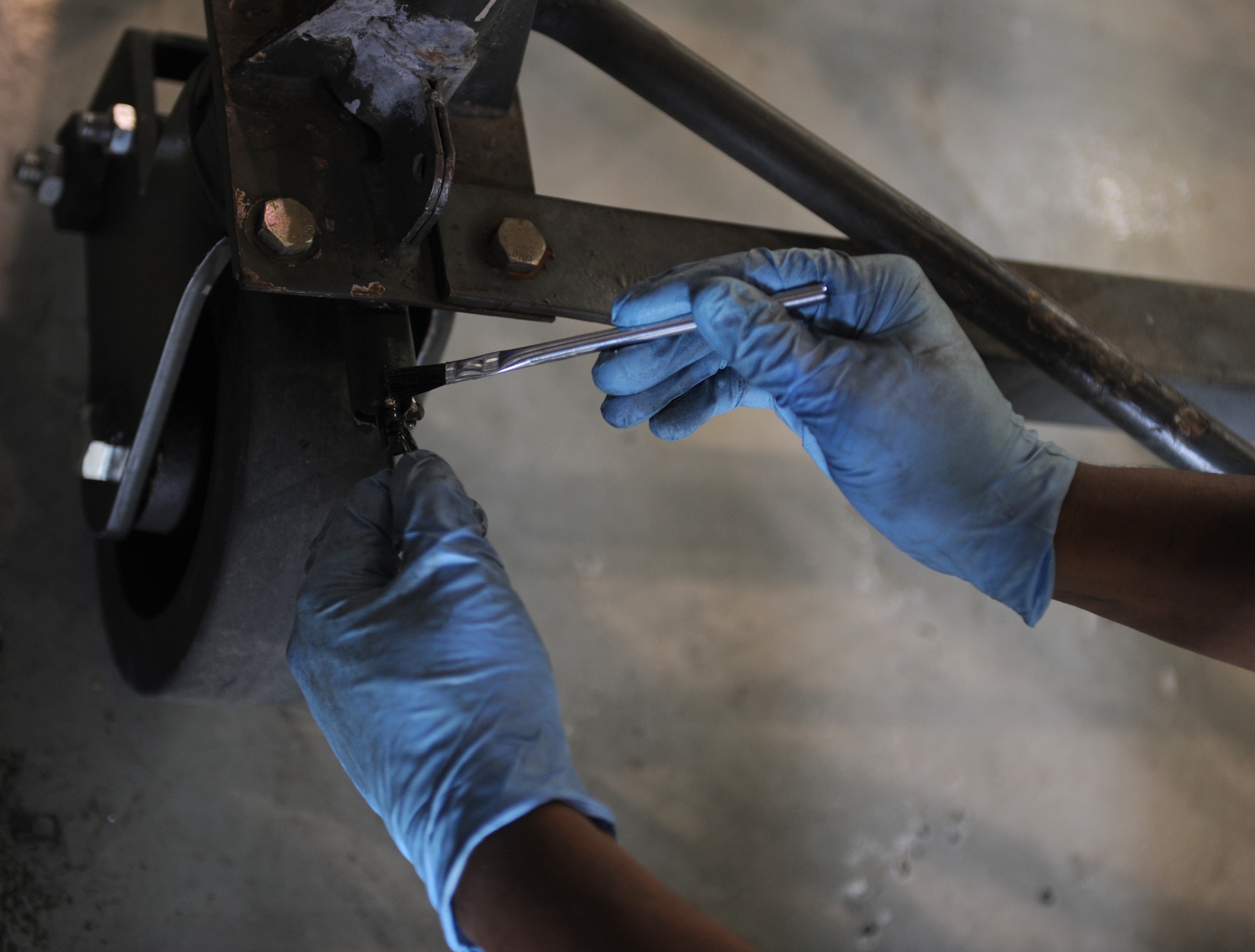 Airman 1st Class Antonio Simon, 2nd Maintenance Squadron Aerospace Ground Equipment flight, lubricates a piece of metal on Barksdale Air Force Base, La., March 28. In order to prevent friction, lubrication oil is placed on all moving parts. (U.S. Air Force photo/Airman 1st Class Benjamin Gonsier)