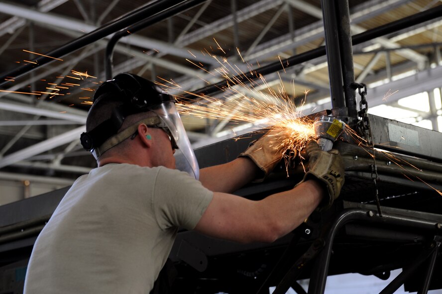 Airman 1st Class Sean Matkosky, 2nd Maintenance Squadron Aerospace Ground Equipment flight, removes a broken chain from a B-5 stand on Barksdale Air Force Base, La., March 28. AGE is responsible for maintaining the equipment used by maintainers to get aircraft off the ground and in the air. (U.S. Air Force photo/Airman 1st Class Benjamin Gonsier)