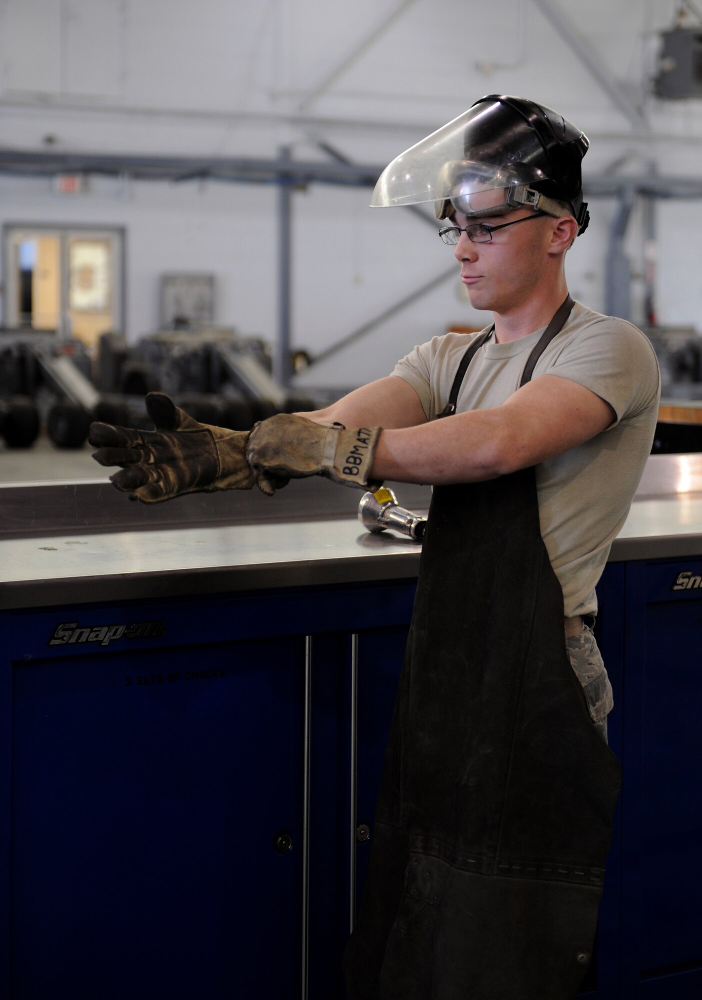 Airman 1st Class Sean Matkosky, 2nd Maintenance Squadron Aerospace Ground Equipment flight, dons personal protection equipment before conducting equipment maintenance on Barksdale Air Force Base, La., March 28. AGE Airmen are responsible for the equipment that helps keep the B-52H Stratofortress operational. (U.S. Air Force photo/Airman 1st Class Benjamin Gonsier)