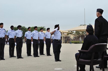 Airman Shakira McElveen salutes Col. Mark Camerer, 37th Training Wing commander, while requesting permission for 343rd Training Squadron regulation drill team members to enter the field of competition at JBSA-Lackland.  (U.S. Air Force photo by Airman Peter McNair/Released)