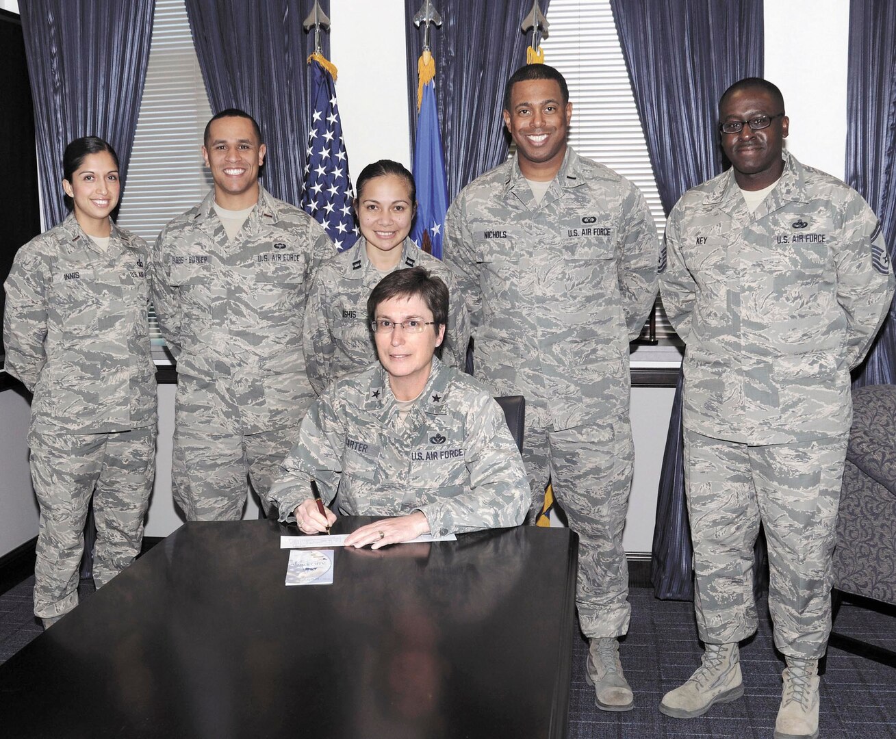 Brig. Gen. Theresa C. Carter, center, Joint Base San Antonio and 502nd Air Base Wing commander, signs her Air Force Assistance Fund pledge at the wing headquarters on JBSA-Fort Sam Houston Tuesday. The general is joined by JBSA AFAF Campaign leads, from left, 2nd Lt. Yuri Innis, 2nd Lt. Alexander Babbs-Butler, Capt. Celestine Lukshis, 1st Lt. Ryan Nichols and Senior Master Sgt. Patrick Key. The AFAF raises funds for four charitable affiliates that provide support to Air Force family members in need: Air Force Villages, Inc.; Air Force Aid Society, Inc.; the Gen. and Mrs. Curtis E. LeMay Foundation and Air Force Enlisted Village, Inc. (U.S. Air Force photo by Joel Martinez/Released)