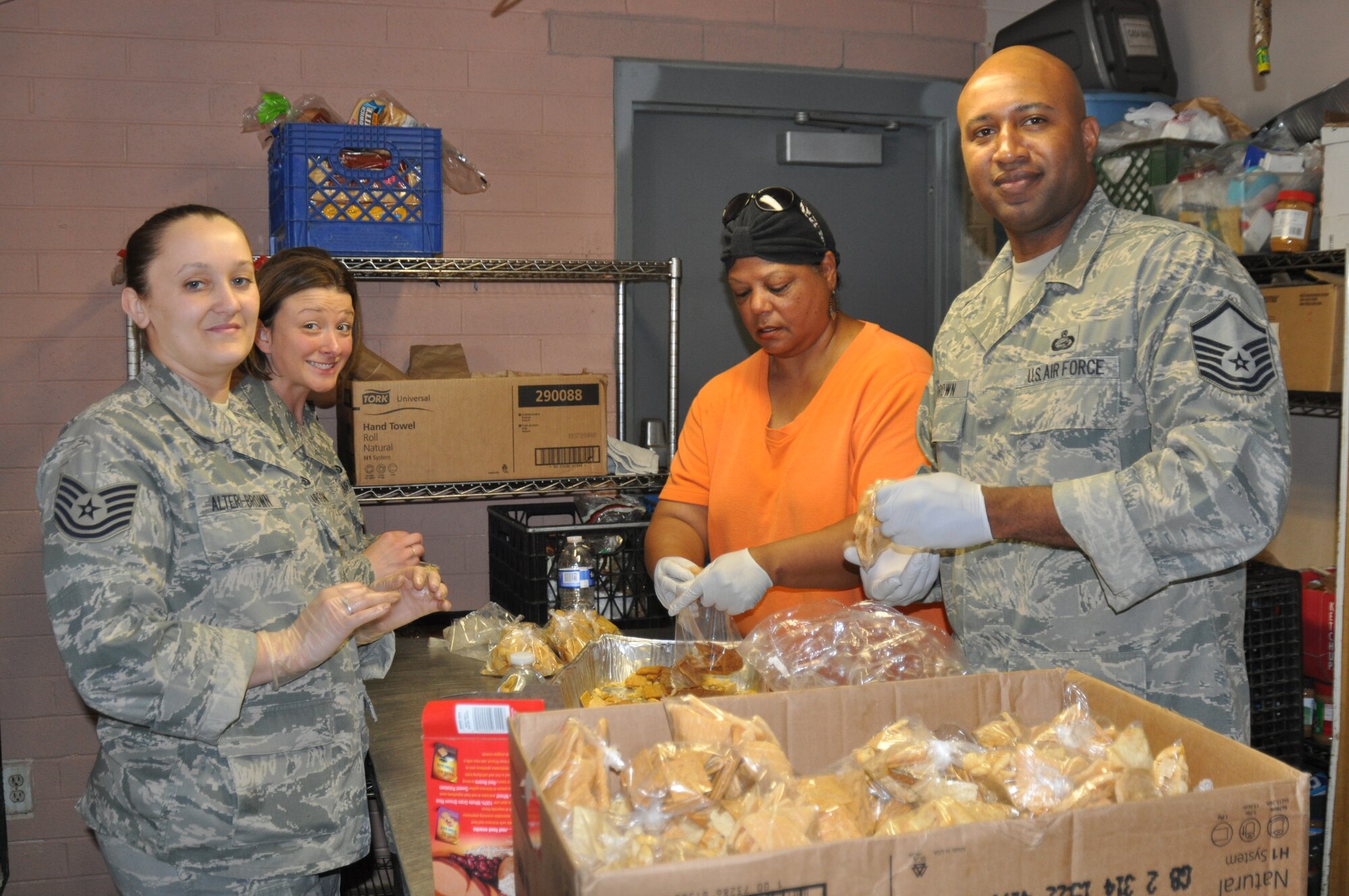 Tech. Sgt. Tiffany Alteri-Brown, Tech. Sgt. Linda Hodgson, Ms. Mary -Claire Avery and Master Sgt. Donnie Brown, all from 12th Air Force (Air Forces Southern), prepare sack lunches for homeless individuals at the Casa Maria Soup Kitchen in Tucson, Ariz., March 28. Over the course of 2-days, members of the organization put together approximately 900 sack lunches, distributed 200 bags of food for needy families, and served more that 400 cups of soup. (USAF photo by Master Sgt. Kelly Ogden/Released). 