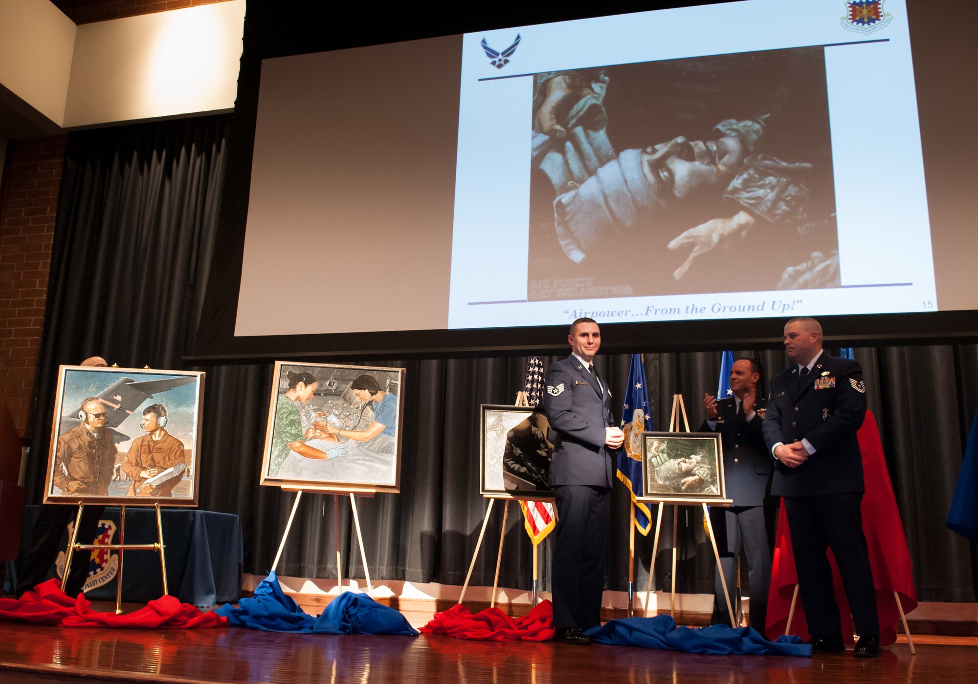 Members of the U.S. Air Force Expeditionary Center unveil the painting titled "Casualty" by John Witt, military artist, Mar. 15, 2013, at the U.S. Air Force Expeditionary Center at Joint Base McGuire-Dix-Lakehurst, N.J. Witt's paintings focused on the EC's training mission. He visited the EC and  sketched the people travel to Afghanistan to sketch people in those same missions doing their jobs in the theater. (U.S. Air Force photo by Russ Meseroll/Released))