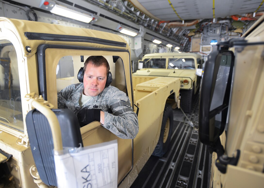 Staff Sergeant Justin Kern, an Air Transportation Craftsman, 60th Aerial Port  Squadron carefully backs a California Army National Guard Humvee Vehicle aboard a C-17 Globamater III.  60th and 349th Air Mobility Wing units along with 49th Military Police Brigade, Fairfield CA participated in this joint exercise.  USAF Photo by T.C. Perkins Jr.  Released