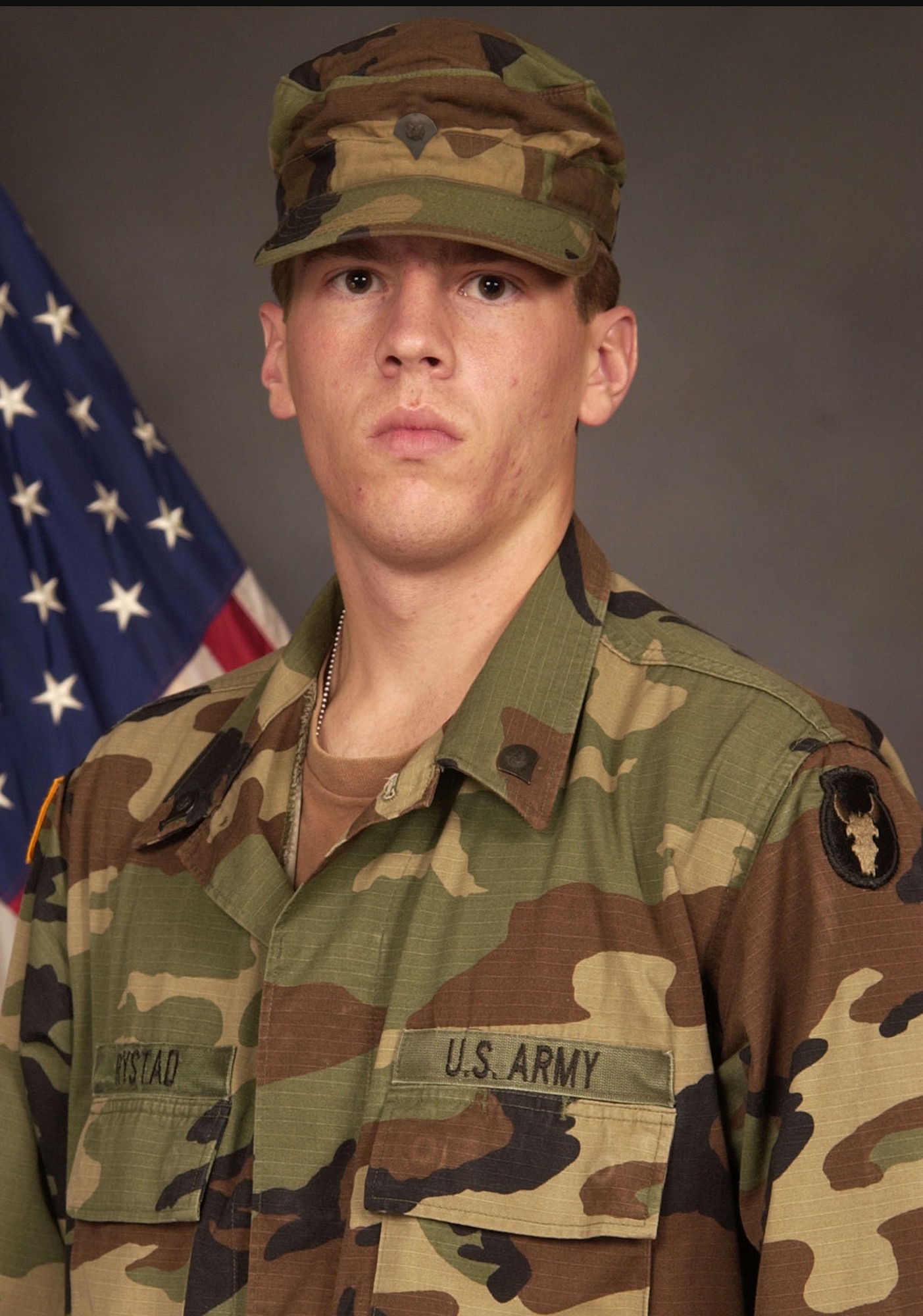 This official Army photo shows Corey J. Rystad wearing the rank of specialist. Sgt. Rystad, of Red Lake Falls, MinnCorey J. Rystad, 20, of Red Lake Falls, Minn., was killed in combat while traveling on a patrol mission near Fallujah, Iraq, after an improvised explosive device detonated near his vehicle on Dec. 2, 2006. His child hood friend, Kurt Philion, honors Rystad’s memory by carrying a 3-foot by 5-foot American flag while running races with a T-shirt bearing an image of the soldier. (File photo courtesy of Minnesota National Guard)