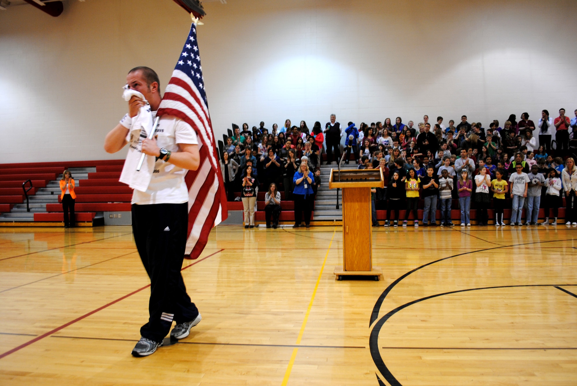 Kurt Philion wipes the tears off his face as he walks away from a podium after delivering a speech about how the death of his friend, an Army sergeant, inspires him to keep running marathons and other races during a March 25, 2013, visit at to Nathan Twining Elementary on Grand Forks Air Force Base, N.D. Philion runs races in memory of his friend, Sgt. Corey Rystad, who was killed in Iraq in 2006. (U.S. Air Force photo/Staff Sgt. Luis Loza Gutierrez)
