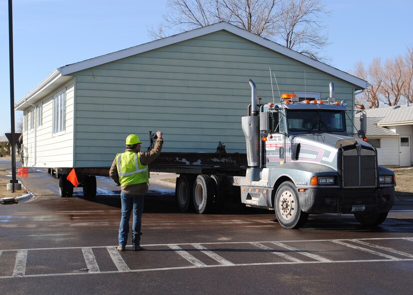 Shawn Moulding directs his partner Dan Stults, in the semi, around a corner in Malmstrom’s housing area March 19.  Moulding and Stults are two members of Abel Moving and Rigging Inc. contracted by Fort Belknap, a Native American Reservation near Havre, Mont., taking the old housing units.  (U.S. Air Force photo/Senior Airman Cortney Paxton)