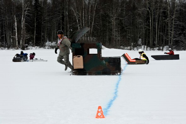 JOINT BASE ELMENDORF-RICHARDSON, Alaska -- Lt. Col. Erik Bruce, commander of the 673d Security Forces Squadron, drags his Humvee sled across the finish line during the Commander Sled Race at Hillberg Ski Area March 24. Commander's raced in cardboard sleds built by their units. (U.S. Air Force photo/Airman 1st Class Omari Bernard)