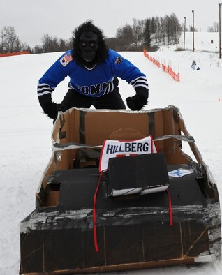 JOINT BASE ELMENDORF-RICHARDSON, Alaska -- Lt. Col. Scott O'Malley, commander of the 673d Communications Squadron, poses in costume in front of his custom-built cardboard sled during the Commander Sled Race at Hillberg Ski Area, March 24. Air Force squadrons across JBER built sleds for their commanders to race in during the Commander's Sled Race. (U.S. Air Force photo/Airman 1st Class Omari Bernard)
