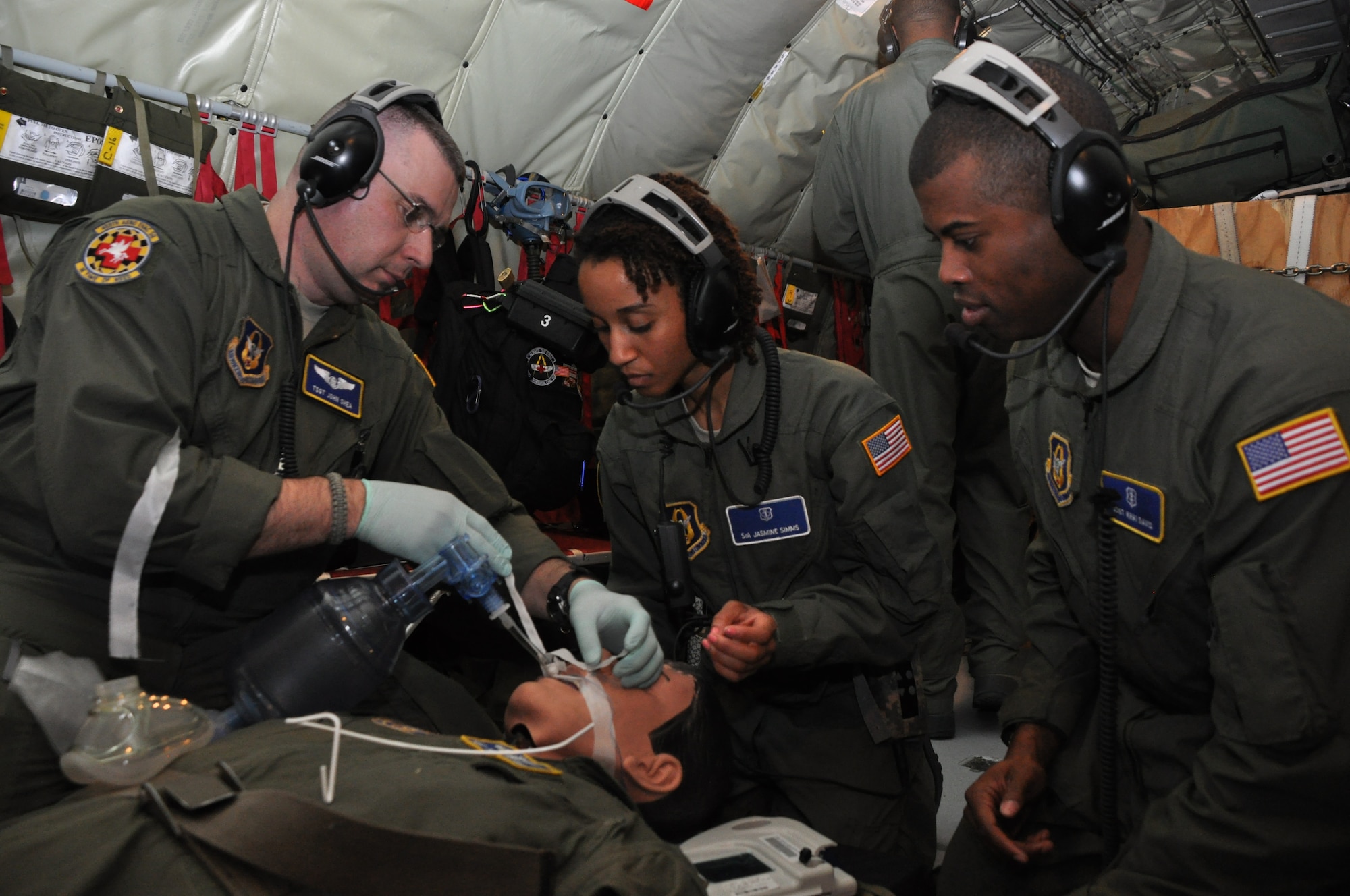 Tech. Sgt. John Shea, a medical technician for the 459th Aeromedical Evacuation Squadron, demonstrates how to properly secure a breathing tube to Staff Sgt. Khai Davis and Senior Airman Jasmine Simms, Critical Care Air Transport Team members with the 459th Aeromedical Staging Squadron at Joint Base Andrews, Md., during a training mission to Texas and California, March 24, 2013. The CCATT teamed up with the 459th Aeromedical Evacuation Squadron to get experience working together and to learn the ins and outs of taking care of patients while airborne. The two teams fly together once every three months. (U.S. Air Force photo/ Staff Sgt. Katie Spencer)
