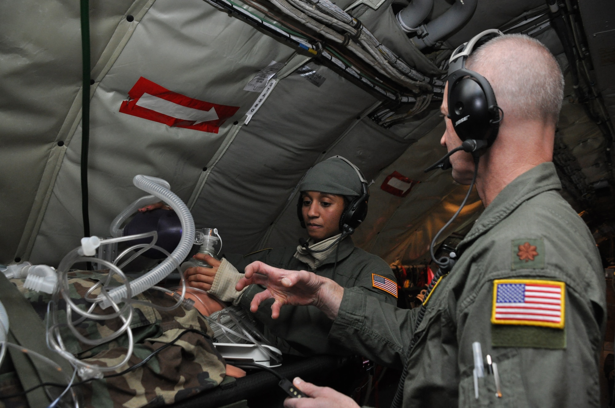 Maj. Patrick Falvey shows Senior Airman Jasmine Simms, Critical Care Air Transport Team members with the 459th Aeromedical Staging Squadron at Joint Base Andrews, Md., how to properly place a breathing bag on a patient during a training mission to Texas and California, March 22, 2013. The CCATT teamed up with the 459th Aeromedical Evacuation Squadron to get experience working together and to learn the ins and outs of taking care of patients while airborne. The two teams fly together once every three months. (U.S. Air Force photo/ Staff Sgt. Katie Spencer)