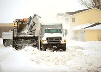 MINOT AIR FORCE BASE, N.D. -- Members of the 5th Civil Engineering Squadron proceed with snow removal near houses at Minot Air Force Base. The 5th CES’ Snow Removal Section runs a 24/7 hour operation from the time of the first snowfall until the last one is anticipated. (U.S. Air Force photo/Airman 1st Class Kristoffer Kaubisch)