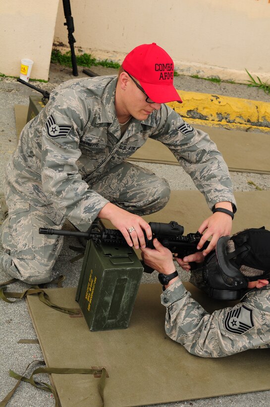 California Air National Guard Staff Sgt. Bryson Barnette a combat arms training and maintenance instructor assigned to the 129th Security Forces Squadron assists Master Sgt. Geoffrey Lewis of the 129th Logistics Readiness Squadron on proper weapons handling, at Moffett Federal Airfield, March 2, 2013. Lewis will be conducting weapons qualification at the Tracey Police Range the following day, in preparation for deployment. (Air National Guard photo by Staff Sgt. Kim E. Ramirez)
