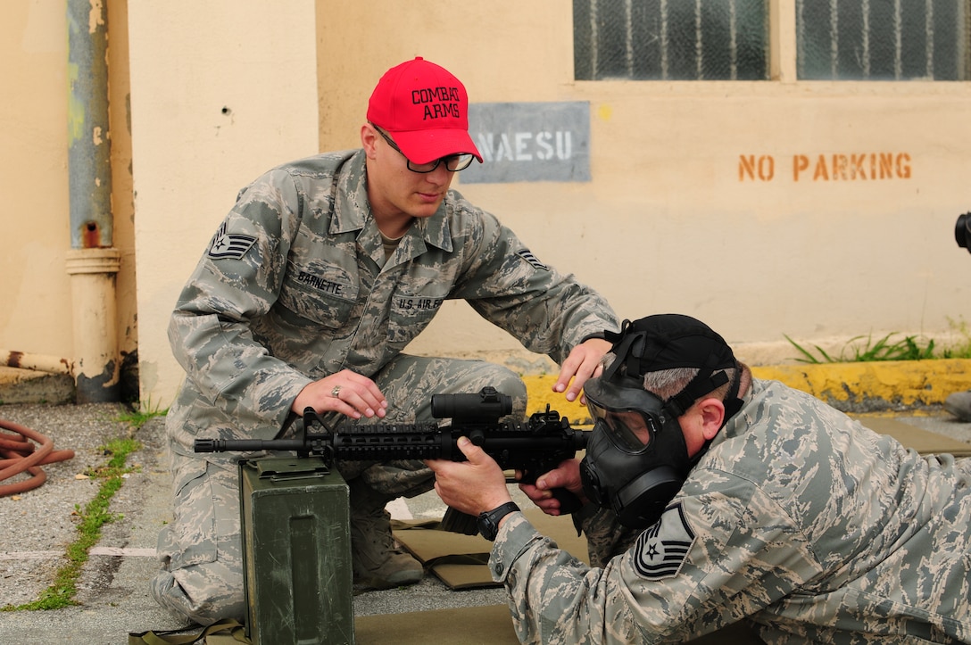 California Air National Guard Staff Sgt. Bryson Barnette a combat arms training and maintenance instructor assigned to the 129th Security Forces Squadron assists Master Sgt. Geoffrey Lewis of the 129th Logistics Readiness Squadron on proper weapons handling, at Moffett Federal Airfield, March 2, 2013. Lewis will be conducting weapons qualification at the Tracey Police Range the following day, in preparation for deployment. (Air National Guard photo by Staff Sgt. Kim E. Ramirez)
