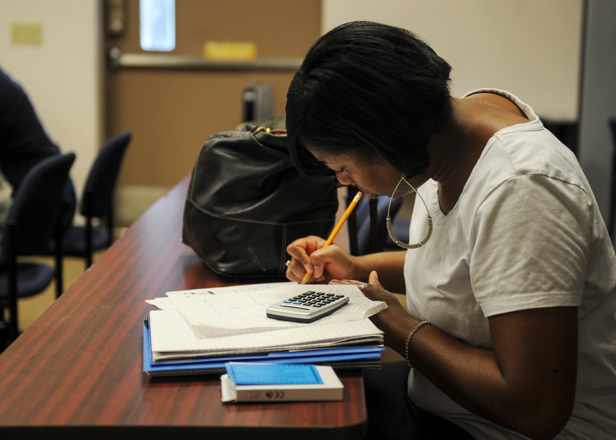 Lashaundra Coad, spouse of U.S. Air Force Master Sgt. Michael Coad, 23d Logistics Readiness Squadron, writes out her expenses during the Financial Lunch and Learn at Moody Air Force Base, Ga., March 21, 2013. During the class, students were given tools to help them reach their financial goals. (U.S. Air Force photo by Airman 1st Class Olivia Bumpers/Released)