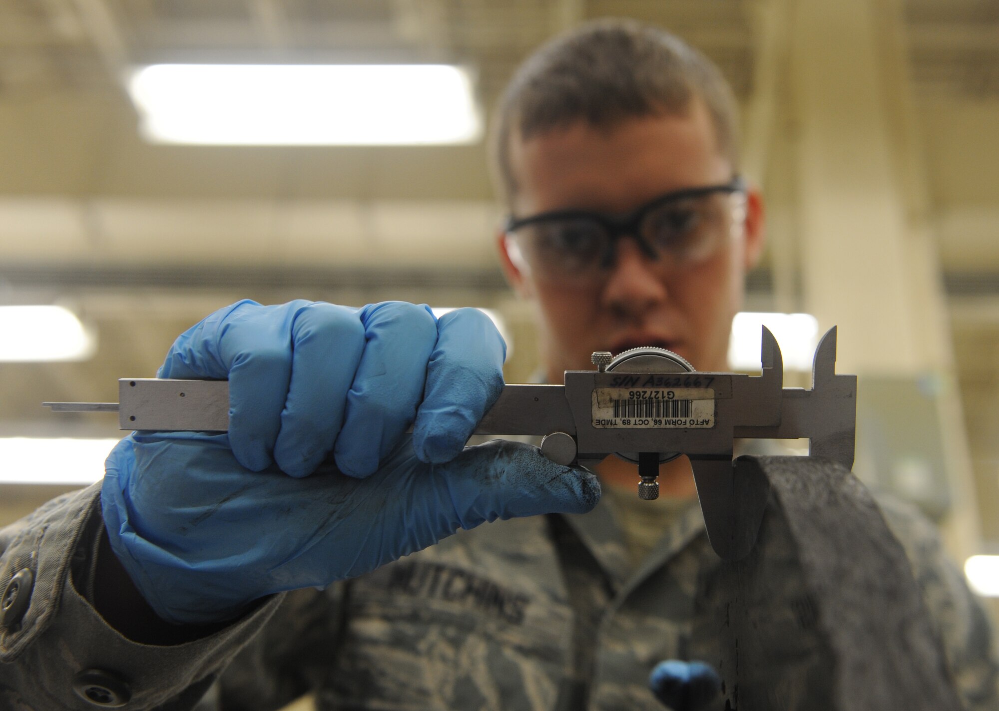 Airmen 1st Class J.C. Hutchins, 509th Maintenance Squadron hydraulic systems repair technician, measures tolerances on a heat stack from a B-2 Spirit brake system at Whiteman Air Force Base, Mo., March 22, 2013. Heat stacks must be measured to ensure they are not below the minimum required tolerance for flight operations. (U.S. Air Force photo by Airman 1st Class Bryan Crane/Released)