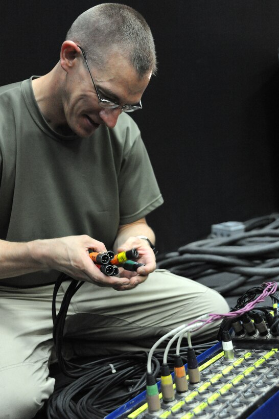 Master Sgt. Mark Hannah, audio engineer for the U.S. Air Forces Central Command Band “Vector” starts making the connections to bring the sound together prior to a performance at a host nation school in Southwest Asia Mar 28, 2013. The AFCENT Band tours throughout the AOR to positively promote troop morale, diplomacy and outreach to host nation communities. (U.S. Air Force photo by Senior Master Sgt. George Thompson)