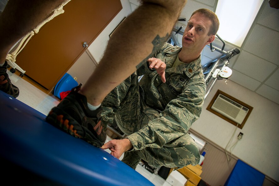 U.S. Air Force Maj. Jon Wilson, 93d Air Ground Operations Wing director of human performance, assists Tech. Sgt. Jasen Brouillette, 820th Combat Operations Squadron assistant innovative combat equipment NCO, while he uses a balance board Jan. 9, 2013, at Moody Air Force Base, Ga . Wilson decided to pursue physical therapy as a career after going through physical therapy in 1992 as an Army sergeant. (U.S. Air Force photo by Staff Sgt. Jamal D. Sutter/Released)   