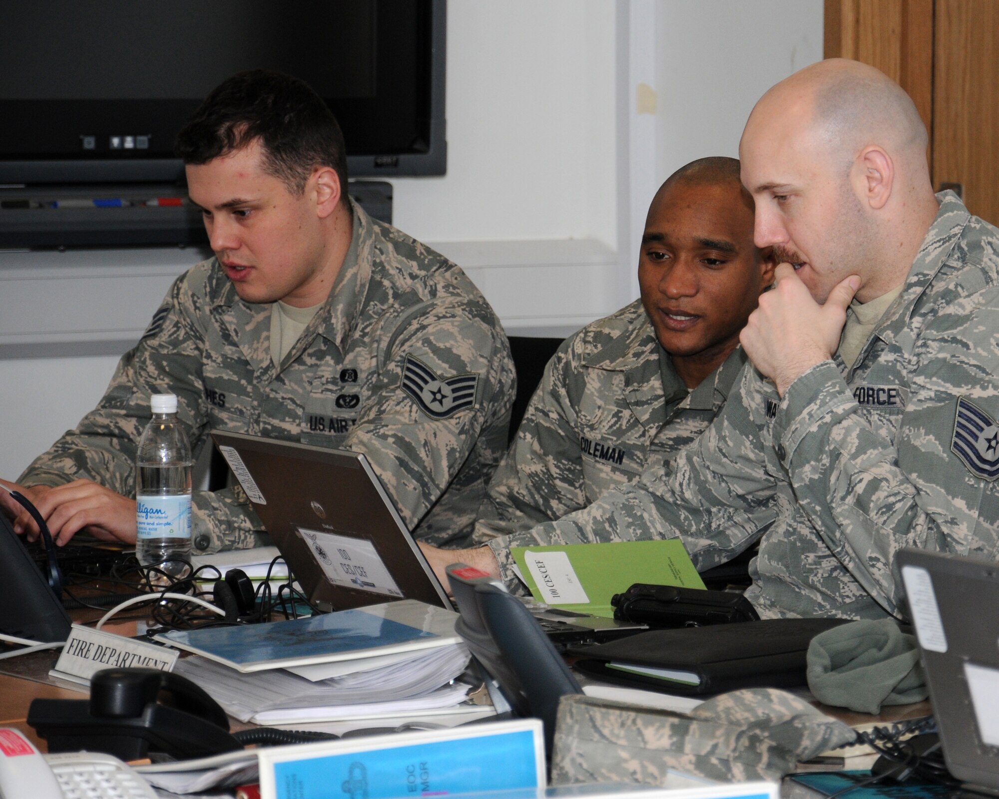 From right, Tech. Sgt. Christopher Waldrip, 100th Civil Engineer Squadron Fire Department assistant chief of fire prevention from San Angelo, Texas, Master Sgt. Corey Coleman, 100th CES Fire Department assistant chief of safety and health from Kansas City, Miss., and Staff Sgt. Christopher Hughes, 100th CES Emergency Management   journeyman from Marshfield, Mass., go through a checklist and bring programs on-line during an exercise March 25, 2013, at RAF Mildenhall, England. The 100th CES is a part of the emergency operations center under the emergency support function-4, firefighting. The fire department coordinates support, firefighting activities and provide updates to the EOC director/manage for the on-scene incident commander. (U.S. Air Force photo by Gina Randall/Released)