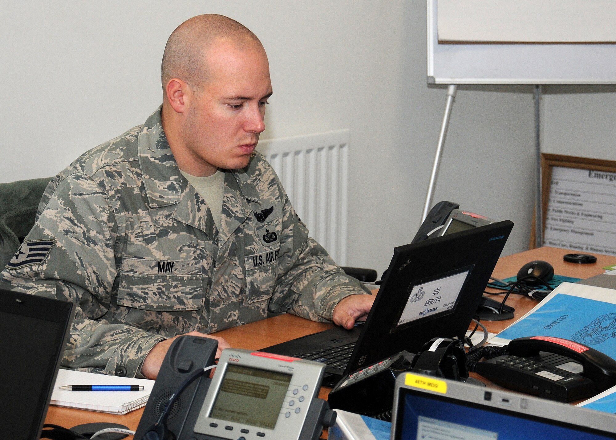 Staff Sgt. Austin May, 100th Air Refueling Wing Public Affairs media relations NCO in charge from Katy, Texas, communicates with his office during an exercise March 25, 2013, at RAF Mildenhall, England. The base’s public affairs office is responsible for releasing information to the base populace and local media agencies through various medias. In the event of an actual emergency the public affairs office will coordinate all official releases of information to the public. (U.S. Air Force photo by Gina Randall/Released)