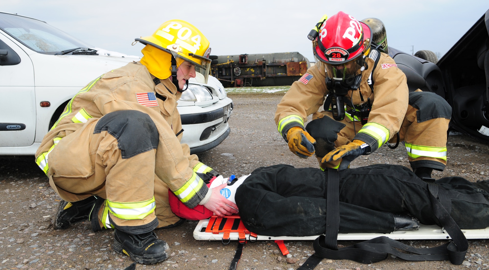 Senior Airman Zachary Peterson, 100th Civil Engineer Squadron Fire Department firefighter from Salt Lake City, Utah, holds a C-spine manual stabilization collar on a simulated patient in triage as Staff Sgt. Cory Pitrat, 100th CES Fire Department firefighter from Phoenix, Ariz., immobilizes the simulated casualty on a backboard during an operational readiness exercise March 25, 2013, at the fire training area on RAF Mildenhall, England.  Firefighters responded when simulated lightning struck a facility and started a fire. The scenario simulated a person who ran out of the building and got hit by a car, which then hit another car, causing it to overturn with three simulated casualties inside. (U.S. Air Force photo by Karen Abeyasekere/Released)