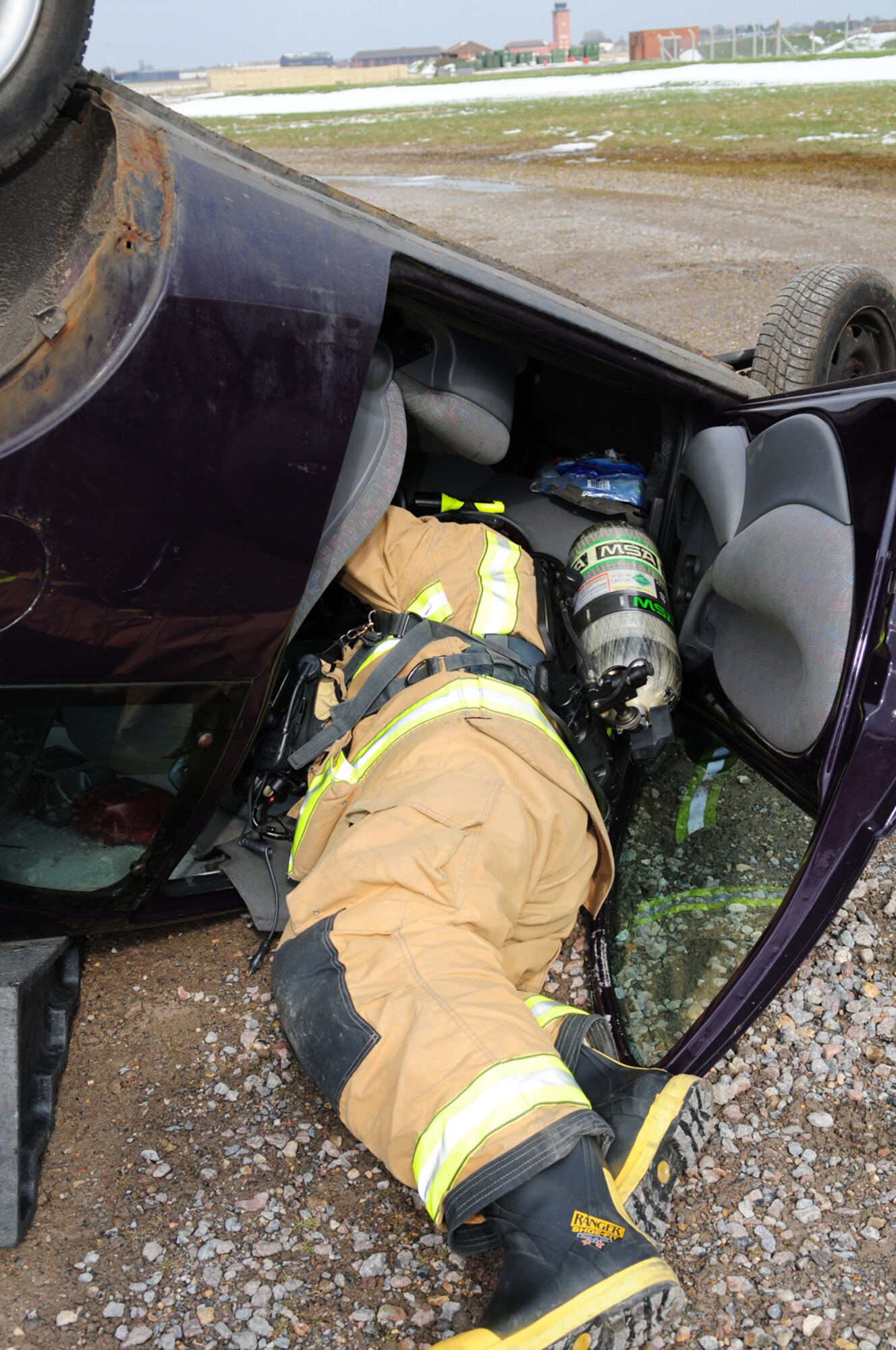 Crew Manager Jeffrey Peacock, 100th Civil Engineer Squadron Fire Department firefighter from Grantham, Lincolnshire, maintains a C-spine manual stabilization collar on a simulated victim inside a vehicle March 25, 2013, after a mock car wreck during an operational readiness exercise at the fire trainer on RAF Mildenhall, England. Firefighters prioritized their response when faced with a building on fire after a simulated lightning strike and car accident. (U.S. Air Force photo by Karen Abeyasekere/Released)
