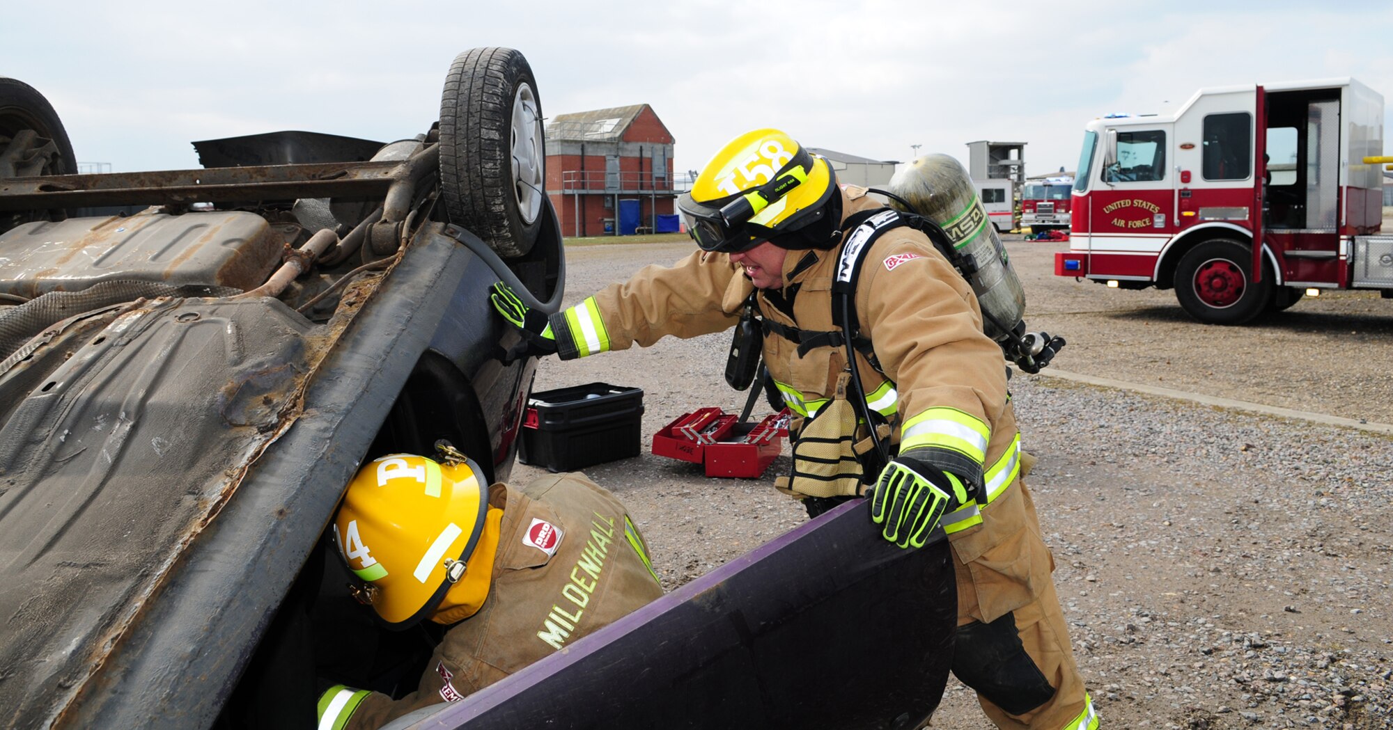 From left, Senior Airman Zachary Peterson, from Salt Lake City, Utah, and Firefighter David Ives from March, Cambridgeshire, 100th Civil Engineer Squadron Fire Department firefighters, complete casualty care on a simulated trapped victim inside an upturned vehicle March 25, 2013, at the fire training area on RAF Mildenhall, England. Firefighters responded after a mock lightning strike hit a facility and started a fire. A person ran out of the building and got hit by a car, which then hit another car, causing it to overturn with three simulated victims inside. After prioritizing their response – the vehicle accident was a risk to life and the building wasn’t mission essential – the first responders rescued the simulated victims from the vehicle and transported them to safety until medics appeared on-scene. (U.S. Air Force photo by Karen Abeyasekere/Released)