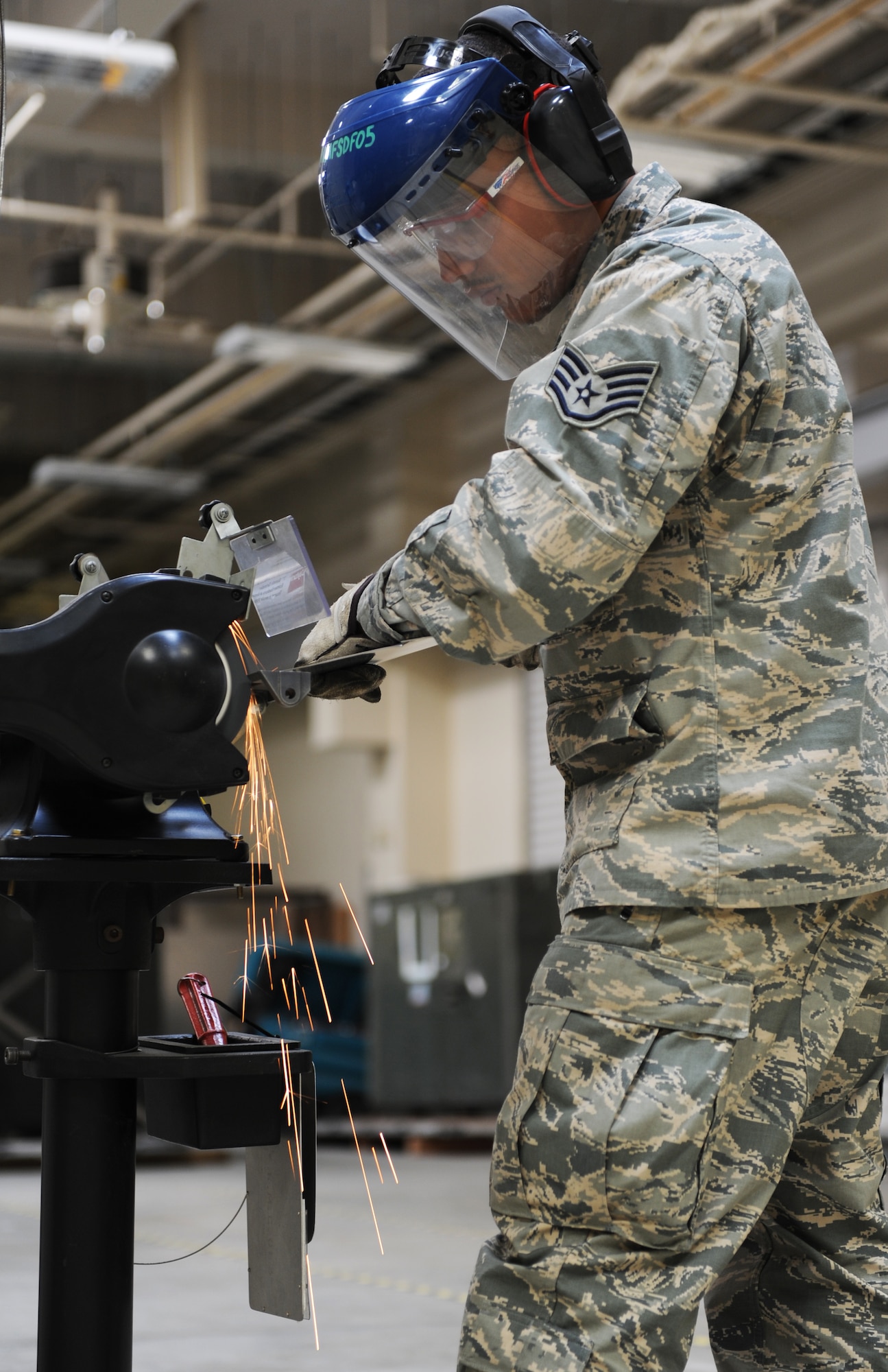 U.S. Air Force Staff Sgt. Montez Lee, 35th Maintenance Squadron fabrication flight aircraft structural maintenance craftsman, grinds a piece of metal at Misawa Air Base, Japan, March 27, 2013. Aircraft structural maintenance Airmen create composite materials, fabricate metals and apply protective paints to aircraft. (U.S. Air Force photo by Airman 1st Class Kia Atkins)