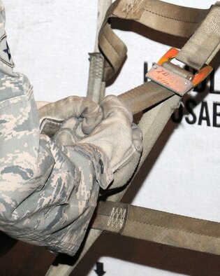 Airman 1st Class Felisha Morris, 100th Force Support Squadron customer service apprentice from Flintstone, Ga., tightens the top net on a pallet March 19, 2013, at RAF Mildenhall, England. Class members learned that they must not over-tighten nets and straps and they must tuck in loose ends. This is so aircraft crewmembers can access the cargo on the pallets if necessary while in-flight. (U.S. Air Force photo by Gina Randall/Released)