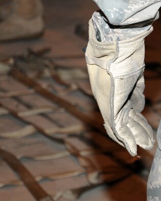 Senior Airman Jared Brown, 100th Force Support Squadron career development assignments and reenlistments journeyman from Midway, Ga., uses personal protective equipment to load a pallet March 19, 2013, at RAF Mildenhall, England. During the briefing prior to the practical part of the training, the trainees learned about the safety equipment they must wear while building a pallet; gloves and steel-toe boots are essential. (U.S. Air Force photo by Gina Randall/Released)