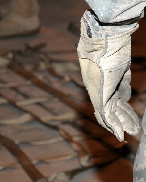 Senior Airman Jared Brown, 100th Force Support Squadron career development assignments and reenlistments journeyman from Midway, Ga., uses personal protective equipment to load a pallet March 19, 2013, at RAF Mildenhall, England. During the briefing prior to the practical part of the training, the trainees learned about the safety equipment they must wear while building a pallet; gloves and steel-toe boots are essential. (U.S. Air Force photo by Gina Randall/Released)