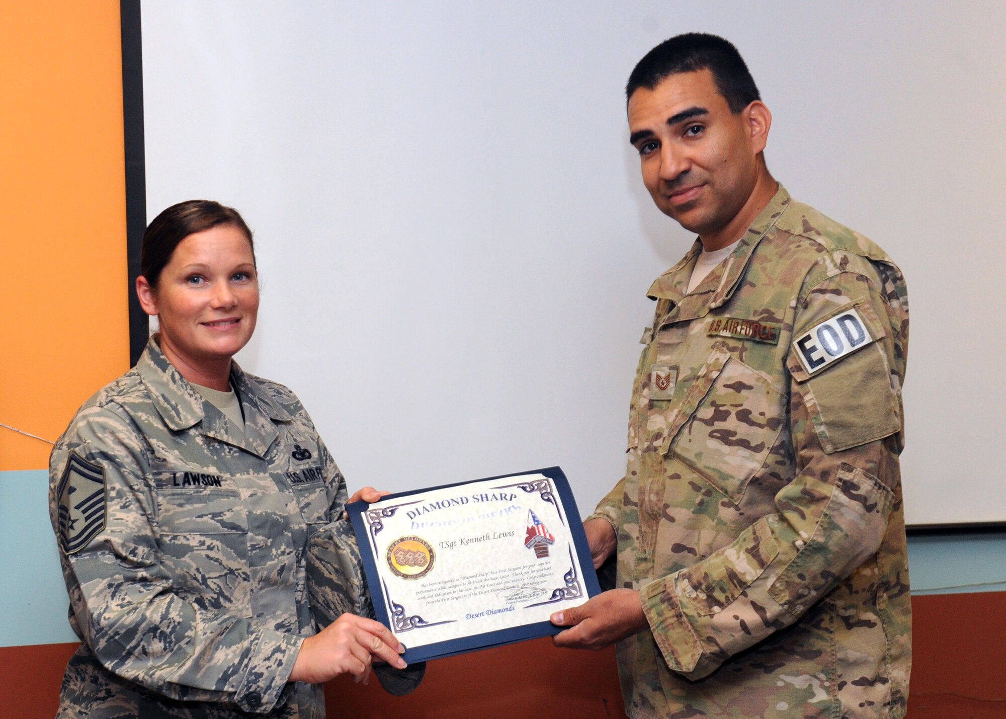 SOUTHWEST ASIA – Senior Master Sgt. Sheila Lawson, 379th Expeditionary Maintenance Squadron first sergeant, presents Tech. Sgt. Kennith Lewis, 379th Expeditionary Civil Engineer Squadron, with the Diamond Sharp Award March 26. The First Sergeants of the Desert Diamond Council recently created the award to recognize Airmen for stellar performance. (U.S. Air Force photo/Senior Airman Joel Mease)