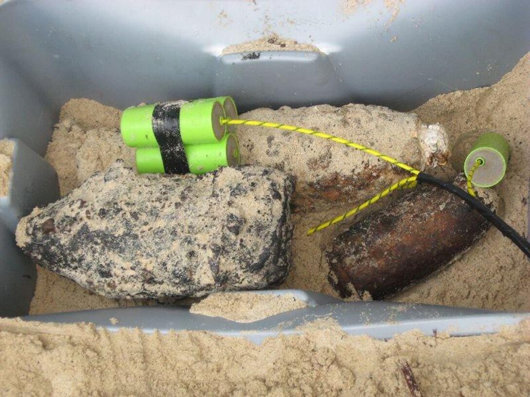 A 5-inch projectile and a BDU-33, along with other munitions that show the effects of time, are prepared for destruction during a Military Munitions Response Program site inspection at a Formerly Used Defense Site on Culebra, Puerto Rico’s northwest peninsula.  The Military Munitions Support Services online workshops allow experts in the field to share best practices on sites like these and others around the U.S.